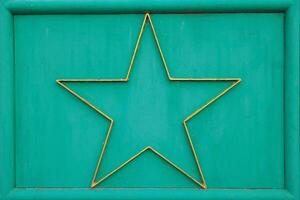 Abstract horizontal texture featuring green metal surface with decorative gold star framed at center. Vintage industrial look ideal for design, art or backgrounds. photo