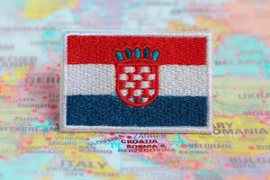 Horizontal shot of Croatia national flag and HR flag embroidered with colorful thread, positioned on world map at Zagreb Croatia. Represents travel, patriotism and cultural heritage. photo