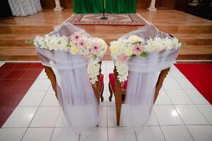 Ceremonial Chairs Decorated with Flowers and Fabrics in a Church, Wedding Ceremony Setting photo