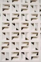 Geometric white facade with repeating square patterns, creating shadows and architectural interest photo