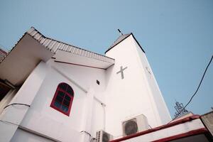 Architectural perspective of a bright white church building with a cross symbol on the facade. photo