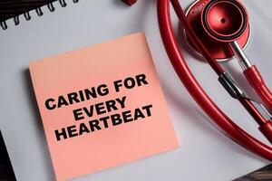 Concept of caring for every heartbeat write on sticky notes isolated on Wooden Table. healthcare and pharmaceutical concept photo