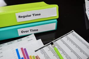 Folders with the label Regular time and over time. Business management concept photo