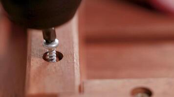 A sequence showing a screw being inserted into wood using an electric drill, highlighting precision and craftsmanship video