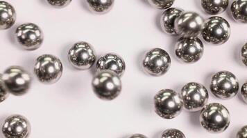Ball bearings fall and collide in a macro close-up, highlighting their metallic texture and dynamic movement video