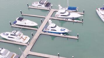 Aerial footage captures boats docked at a marina in Port Douglas, Australia. Calm waters and clear skies create a serene atmosphere video