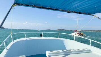 A boat sails through turquoise waters under clear skies in Chalong Bay, Phuket, capturing serene ocean views and distant islands video