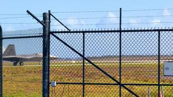 An F-22 Raptor taxis on a runway behind a fence at Avalon Airshow, Geelong, under clear skies video