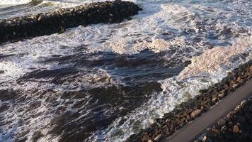 Dynamic ocean waves crash against a rocky breakwater at Brunswick Heads, NSW, captured in soft, natural lighting video
