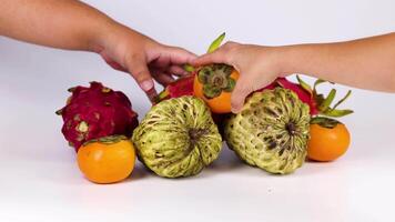 Hands selecting and removing fruits from a pile video