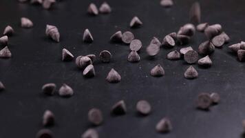 Chocolate chips scattered across a dark surface video
