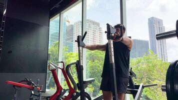 A man performs chest press exercises in a modern gym with cityscape views, showcasing strength and fitness video