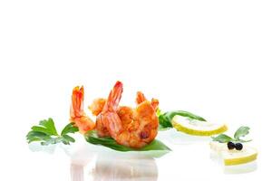 Delicious sea shrimps with lemon isolated on white photo