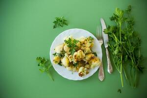 Top view of crispy cauliflower with parsley on a green background . photo