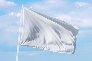 White flag waving under soft clouds, perfect for themes of surrender, calm communication, or neutral design in web or print projects photo
