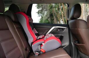 Side view of a child safety seat in the back seat of a premium car with leather interior photo