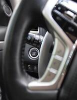 Start Engine Button, Active Control Button Of Parking Sensors And Stability Control System Under Steering Wheel Inside A Car photo