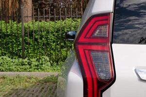 Back Light Of Vehicle Stay In Front Of Fence Of Forest Park photo