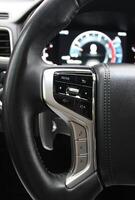 Buttons And Electronic Control Panel On A Steering Wheel And Blurred Digital Dashboard Inside Modern Car photo