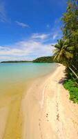 Cinematic FPV drone flight over tropical beach with palm trees, white sand, and crystal-clear turquoise sea on Koh Kood island in Thailand. Aerial view of exotic coastline and paradise landscape. video
