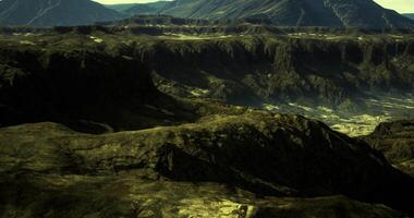 CGI rugged, mountainous landscape, likely characterized by volcanic or eroded rock formations, presented in low light or golden hour conditions video