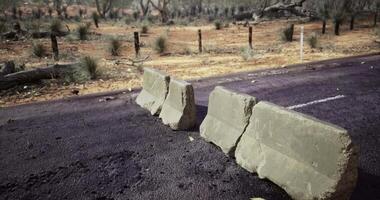 CGI concrete road barrier blocks in a remote or rural setting, likely in the Australian outback. video