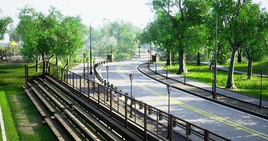CGI an empty asphalt road winding through a city park or green space, flanked by lush green trees and lampposts video