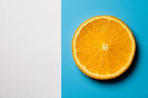 Whole orange slice, on blue and white background. Top view. Flat lay, mockup for text photo