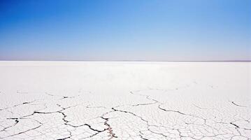 Vast Dry Cracked Earth Landscape Under Clear Blue Sky Arid Salt Flat Scenery photo