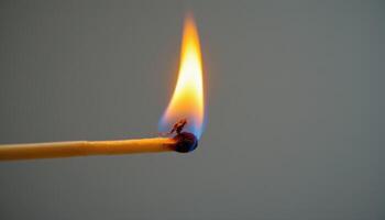 close up view of a flame burning steadily on the tip of a long matchstick, its glow contrasting with the dark background. photo