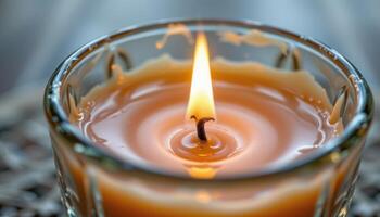 close up view of a flickering candle flame surrounded by melted wax in a vintage glass holder. photo