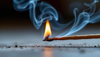 close up view of a tiny flame dancing atop a burning incense stick, the smoke curling and blending with the soft orange glow. photo
