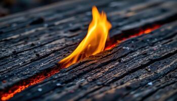 close up view of fire licking across a charred wooden surface, creating glowing red lines. photo