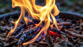 close up view of flames intertwining and twisting as they rise from a pile of dry leaves. photo