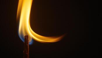 close up view of a slender flame bending in a gentle breeze, its movement smooth and hypnotic against a dark background. photo