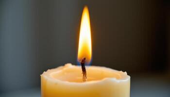 close up view of a flame climbing up the wick of a tall taper candle, surrounded by softly melting wax. photo