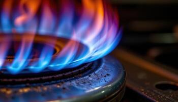 close up view of blue flames licking along the edge of a metal burner, glowing with intense heat. photo