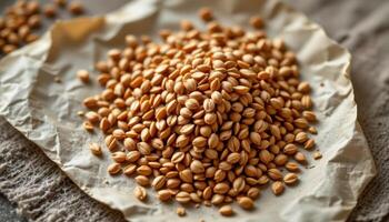 close up view of golden flax seeds densely grouped on handmade parchment paper with fibrous texture. photo
