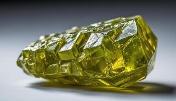 close up view of a rough peridot crystal with olive green hues and semi translucent edges illuminated from behind. photo