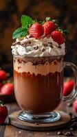 Strawberry-topped hot chocolate. A rich hot chocolate topped with whipped cream and fresh strawberries, served in a glass mug on a wooden table. photo