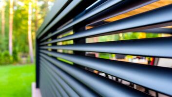 Modern outdoor space with sleek design. Close-up view of stylish slatted exterior featuring a contemporary outdoor living area surrounded by trees. photo