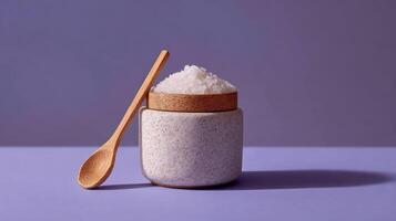 Ceramic jar filled with sugar scrub and wooden spoon placed on a pastel surface for a relaxing self care experience photo