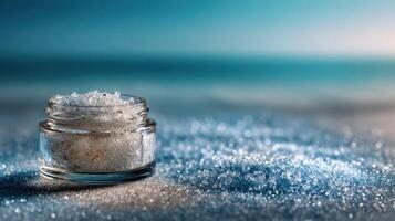 Bath salts in a glass container on beach sand with ocean backdrop during sunset near the coast photo