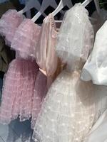 Pink and white dresses with sequins creating a delicate and textured background photo