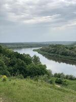 Scenic river landscape with lush greenery and cloudy sky, perfect for nature background photo