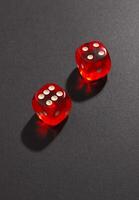 Red and white dices on black photo