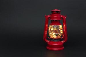 Glowed old lantern on a black back photo