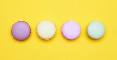 Colored macarons on a yellow photo