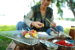 A woman is sitting on a picnic table with a plate of food in front of her photo