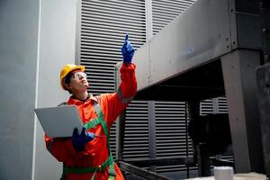 A man in a red jacket is pointing at a piece of equipment photo